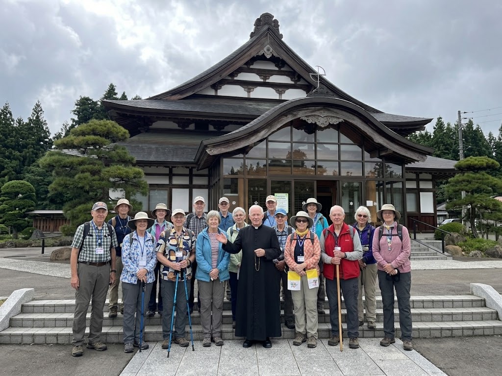 Pilgrimage group with a priest outside a historic building in Japan