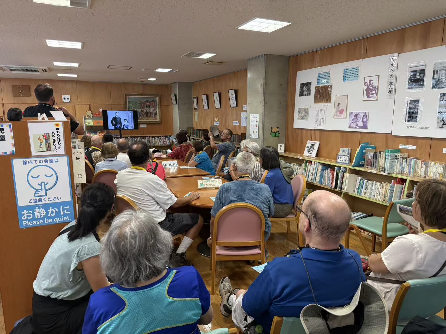Pilgrims seated together watching a historical presentation in Japan