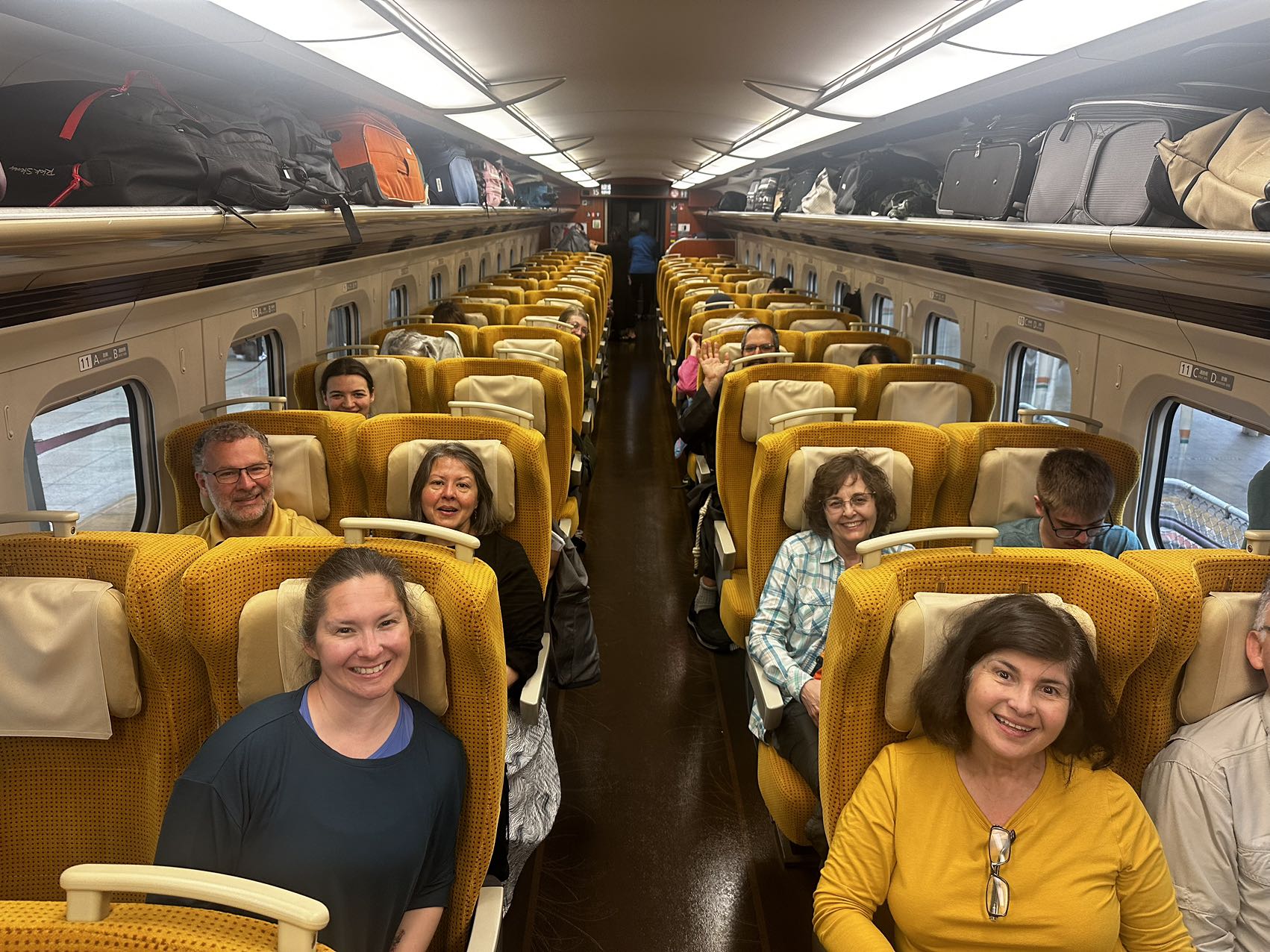 Catholic pilgrims smiling together aboard a train in Japan