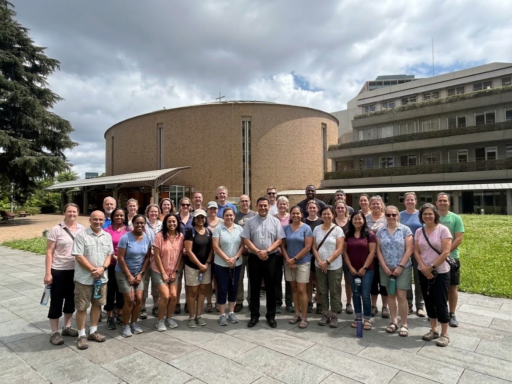Pilgrimage group with a priest outside a Catholic church